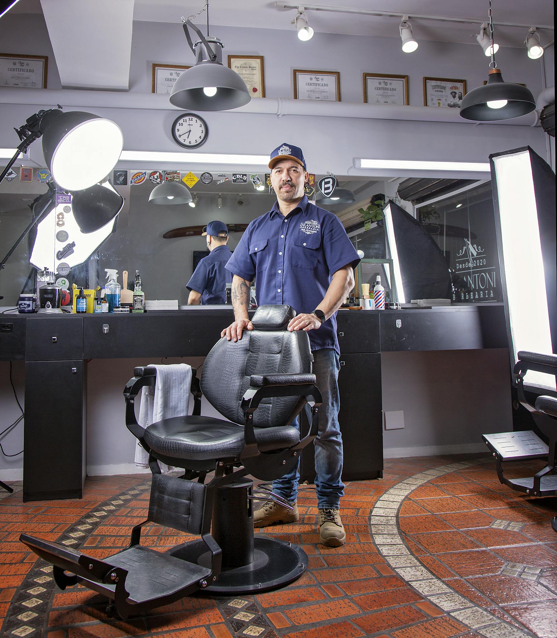 Barber standing proudly in a well-equipped, modern salon with stylish interiors.